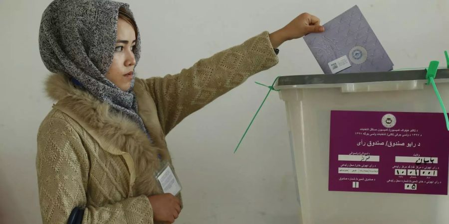 Eine Wählerin wirft in Afghanistan ihren Stimmzettel für die Parlamentswahlen in eine Wahlurne.