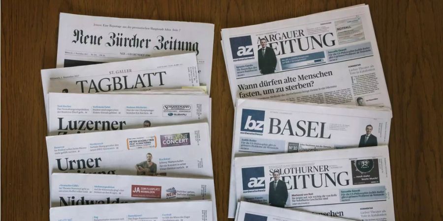 Zeitungen der AZ Medien und der NZZ Mediengruppe liegen auf einem Tisch.