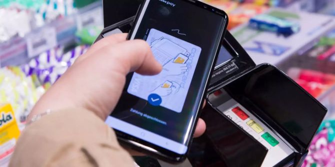 Eine Person nutzt die Bezahlfunktion von Samsung Pay in einem Kiosk.