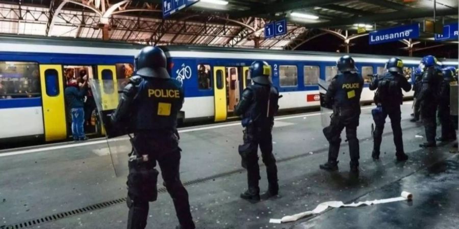 Bahnpolizisten warten vor einem Extrazug.