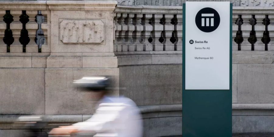 Ein Velofahrer passiert den Swiss Re Hauptsitz in Zürich.