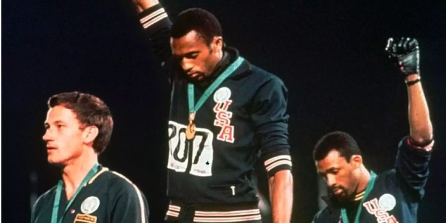 Tommie Smith (Mitte) und John Carlos (rechts) recken die Faust in die Luft. Links: Peter Norman (Australien).