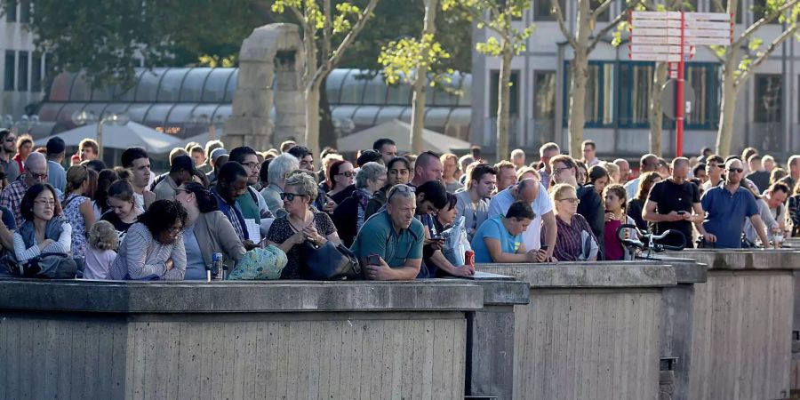 Dutzende Reisende warten während der Geiselnahme in der Nähe des Kölner Hauptbahnhofs.