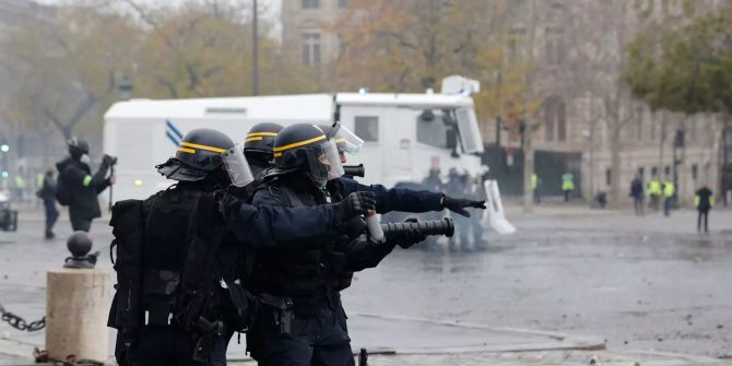 Polizisten sind während einer Demonstration in der Nähe des Arc de Triomphe im Einsatz.