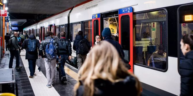 Pendler steigen in einem Zug ein und aus.