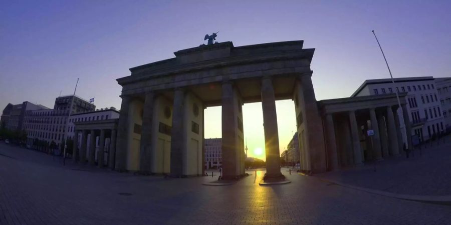 Die Sonne geht hinter dem Brandenburger Tor auf.