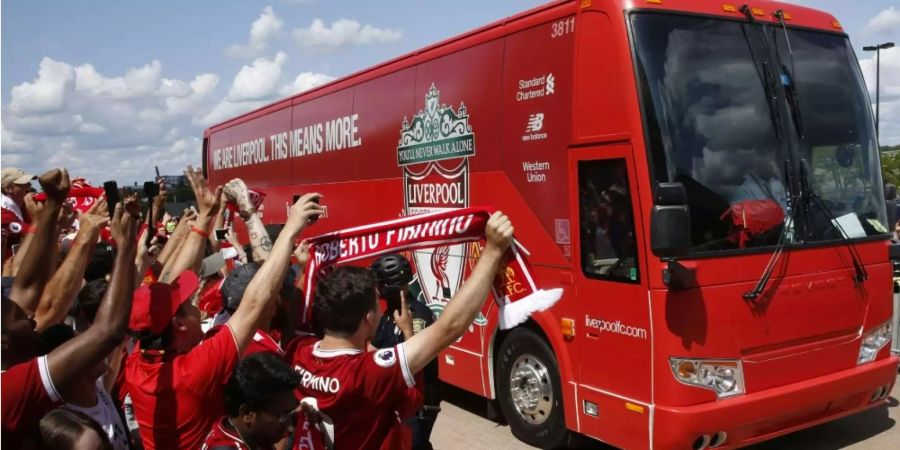 Fans bejubeln frenetisch den anfahrenden Bus des Fussballklubs Liverpool.