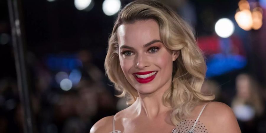 Margot Robbie strahlt in die Kamera.