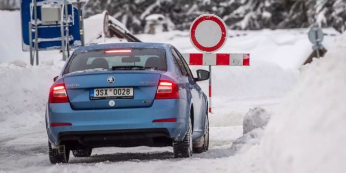 Ein Auto steht vor einer Strassensperre im verschneiten Riesengebirge Ein Auto steht vor einer Strassensperre im verschneiten Riesengebirge
