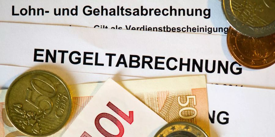 Auf Lohnabrechnungen liegt Geld.
