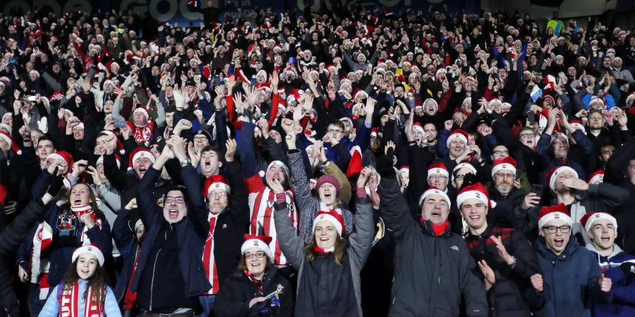 Die Southampton-Fans mit Weihnachtsmützen singen auf der Tribünen.