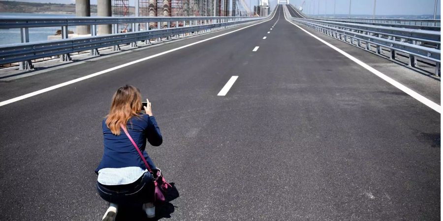 Eine Journalistin fotografiert die neue Brücke, die die Halbinsel Krim mit dem russischen Festland verbindet.