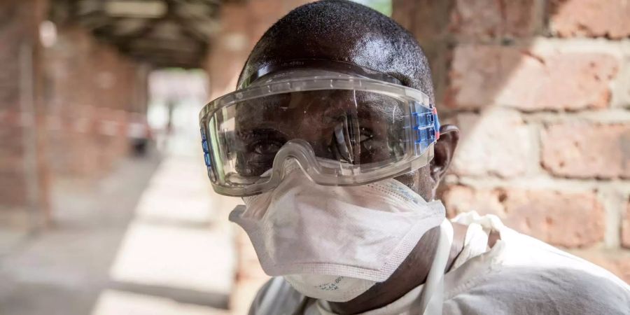 Ein Mitarbeiter des Gesundheitswesens trägt in einem Ebola Behandlungszentrum Schutzkleidung.