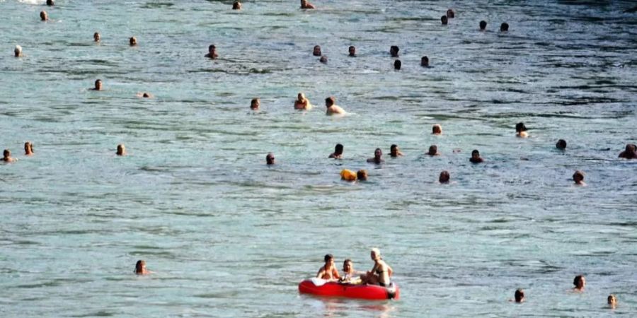 Menschen schwimmen in der Aare in Bern.