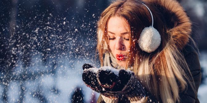 Frau hält Schnee in Hand