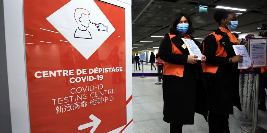 Zwei Flughafenmitarbeiterinnen warten auf dem französischen Flughafen Roissy-Charles de Gaulle auf Passagiere aus China.