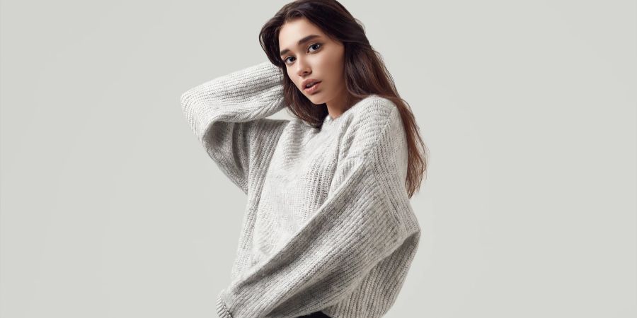 Model in grauem Wollpullover.