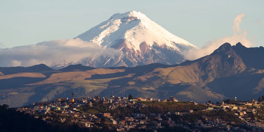 Quito mit verschneitem Berg im Hintergrund.