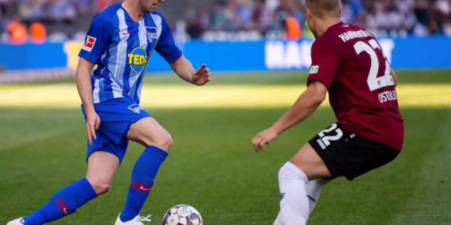 Herthas Klünter (l) liefert sich mit Hannovers Ostrzolek in einem chancenarmen Spiel einen Zweikampf. Foto: Lisa Ducret