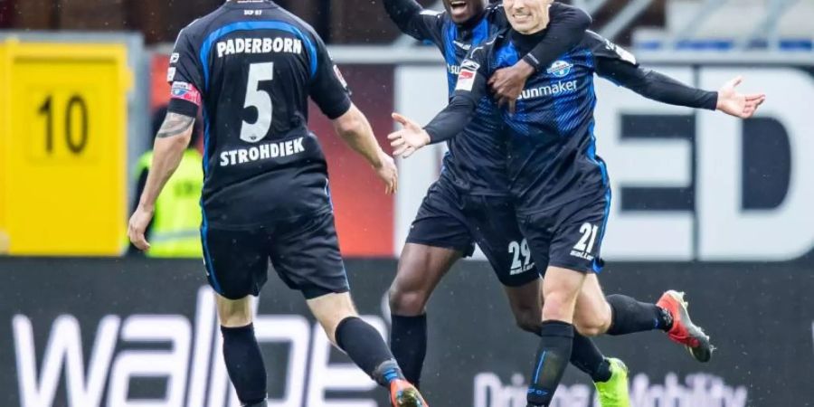 Die Paderborner Christian Strohdiek (l-r), Jamilu Collins und Philipp Klement freuen sich über einen Treffer gegen Ingolstadt. Foto: Marcel Kusch