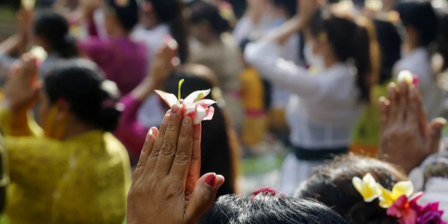 Menschen beten während eines Hindu-Rituals. An heiligen Orten verhalten sich Balis Touristen oft despektierlich. (Archivbild)