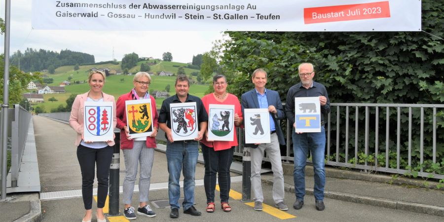 Gemeindevertreter stehen auf einer Brücke