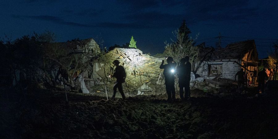 Ukrainische Polizisten dokumentieren die Schäden an Häusern, die von einem Raketenangriff auf ein Wohnviertel in Pokrowsk getroffen wurden.