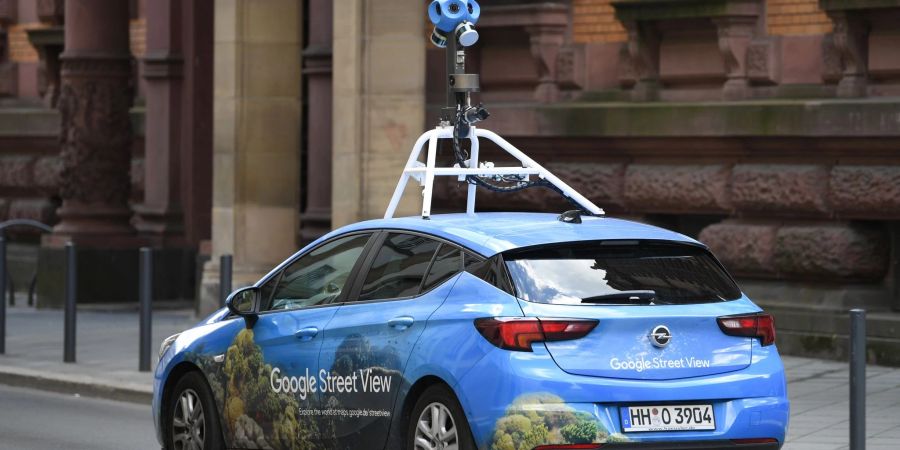 Mit einer auffälligen Kamera auf dem Dach fährt ein Auto von Google Street-View durch das Gerichtsviertel in Frankfurt.