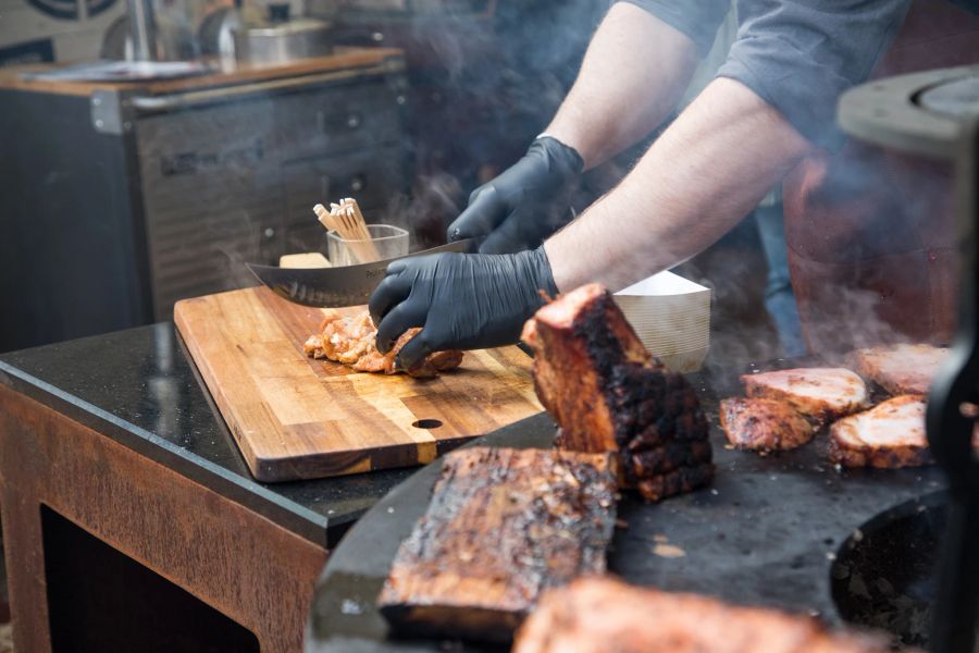 Mann Grillgut Messer Holz Hände