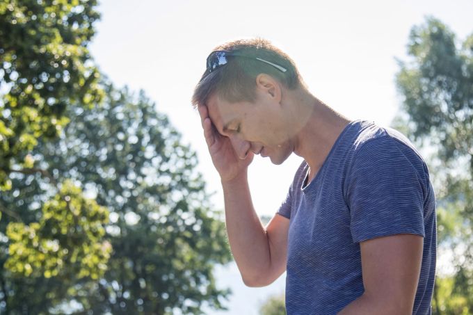 Starke Kopfschmerzen und Schwindel? Das kann auf einen Sonnenstich hindeuten. Auch ein hochroter, heisser Kopf ist ein Anzeichen. Mann Sommer Kopf Sonnenstich