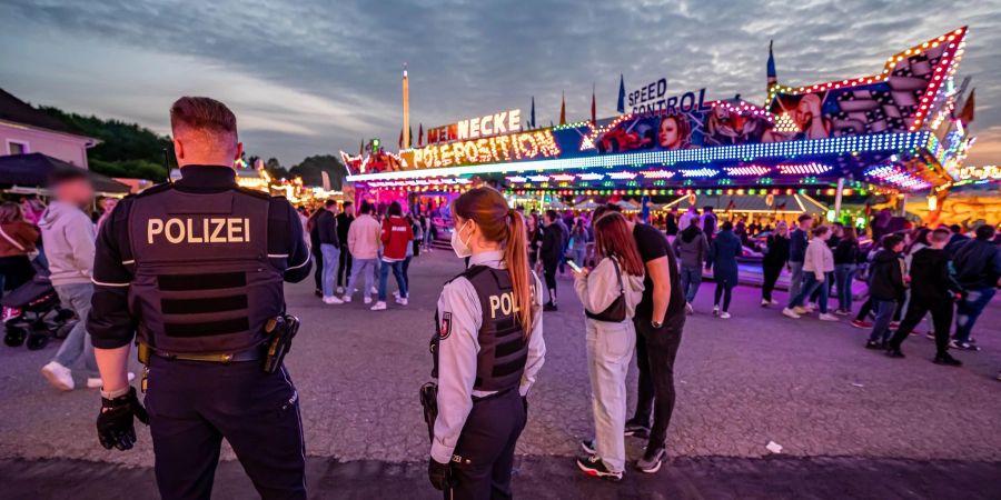 Polizeibeamte stehen auf dem Kirmesgelände, wo ein Mann erschossen wurde.