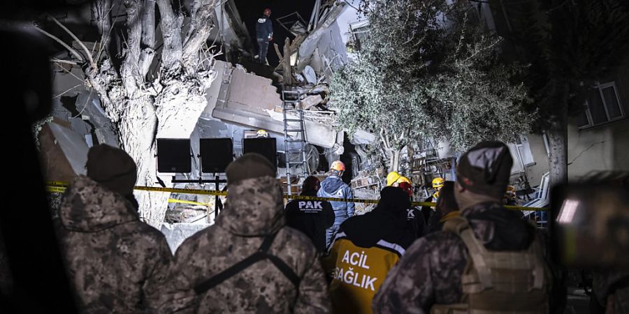 Mitglieder eines Rettungsteams suchen nach Menschen in einem zerstörten Gebäude. Foto: Ugur Yildirim/DIA/AP/dpa