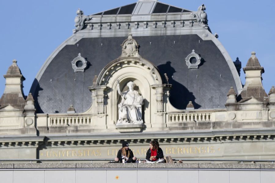 Zwei junge Frauen geniessen das schöne Wetter auf der Grossen Schanze vor der Universität Bern.