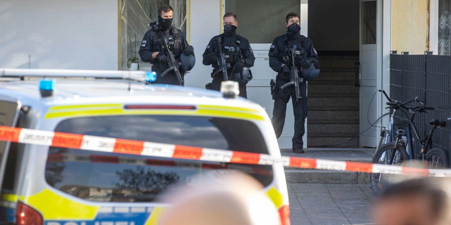 Polizisten stehen im Stadtteil Hackenbroich vor einem Kiosk. Hier wurde ein Mann erschossen. Die Polizei fahndete mit Dutzenden Beamten nach dem Schützen und nahm die Spurensicherung auf.