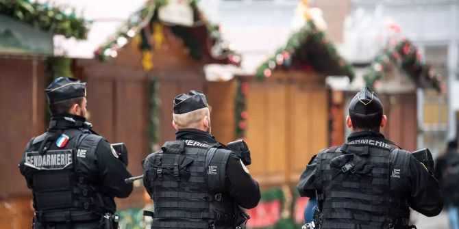 Polizisten gehen nach einem Angriff in der Gegend des Strassburger Weihnachtsmarkts über den geschlossenen Weihnachtsmarkt.