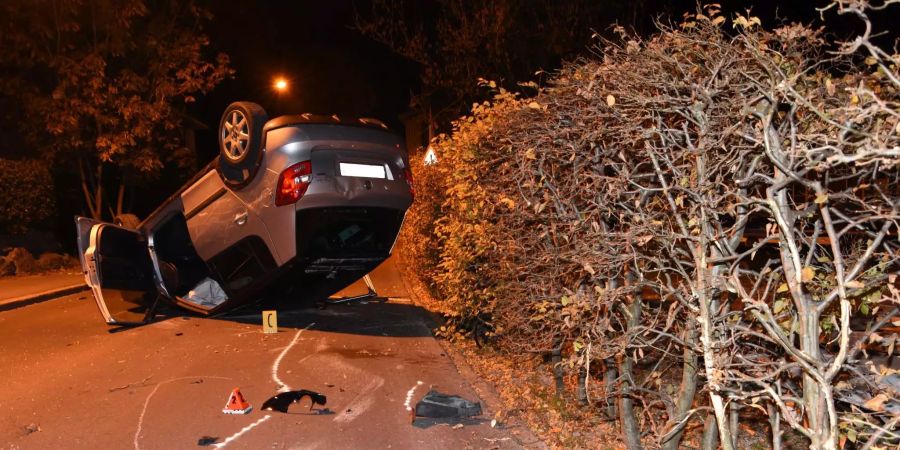 Das betroffene Auto liegt neben einer Hecke auf dem Dach.