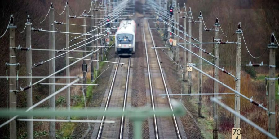 Ein Personenzug fährt auf einer zweigleisigen elektrifizierten Bahnstrecke zwischen Schwerin und Wismar (D).