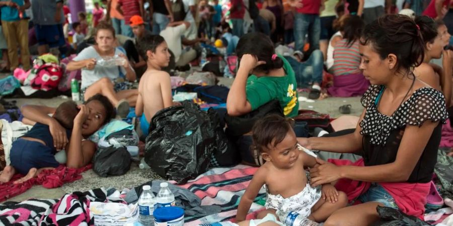 Eine Gruppe von Migranten wartet in einem Park in Mexiko.