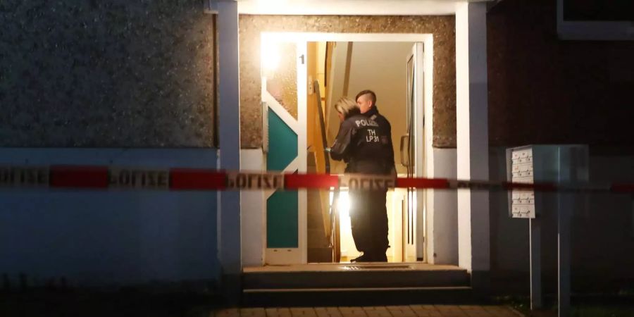 Polizeibeamte stehen im Eingang eines Wohnhauses. Hier wurden vier Leichen gefunden. Zu Alter und Geschlecht der Toten konnte ein Polizeisprecher am Abend zunächst keine Angaben machen. Genauso wenig sei bisher bekannt, unter welchen Umständen die vier Menschen ums Leben kamen.