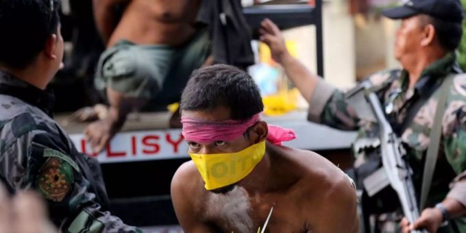Die philippinische Regierung und die MILF nähern sich an. Polizisten führen MILF-Rebellen ab.