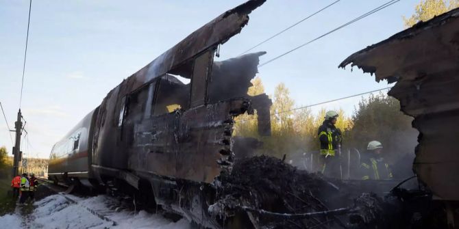 Feuerwehrleute sind nach dem Brand eines ICE auf der Schnellstrecke zwischen Köln und Frankfurt in der Nähe von Montabaur mit Nachlöscharbeiten beschäftigt.