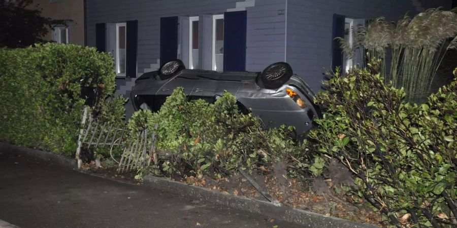 Das Auto liegt nach einer Kollision mit der Hausfassade auf dem Dach.