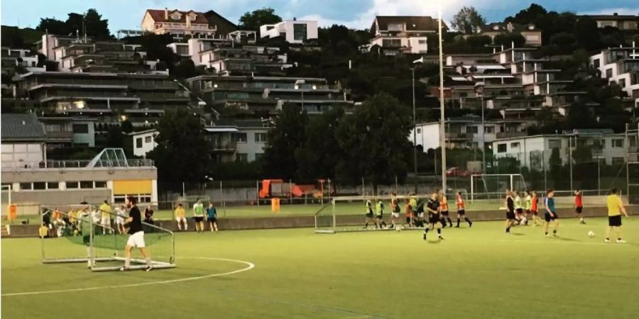Mehrere Menschen spielen auf dem Sportplatz