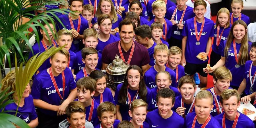 Roger Federer inmitten von Ballkindern.