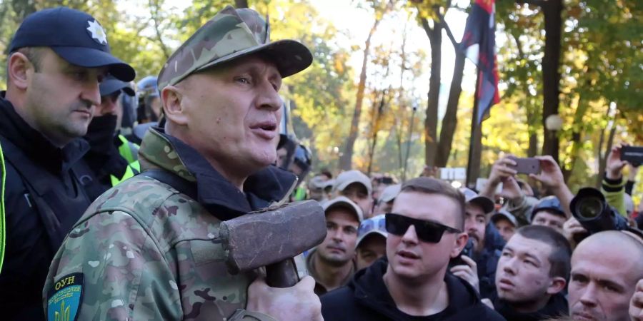 Der Ultra-Nationalist und OUN-Kommandeur Mykola Kochanowski hält einen Hammer in der Hand, während die Demonstranten bei einem Protest in der Nähe des Parlamentsgebäudes in Kiew versuchen, ein Denkmal aus der Sowjetzeit zu zerstören.