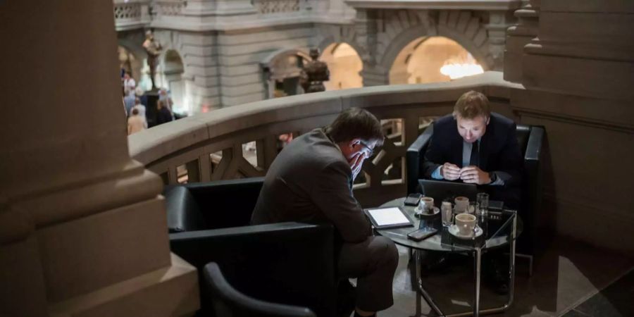 Nationalrat Philippe Nantermod, FDP-VS, rechts, und sein persönlicher Mitarbeiter Andre Vernay arbeiten an Computer und Tablet in der Eingangshalle des Parlamentgebäudes, an der Herbstsession der Eidgenössischen Räte, am Dienstag, 11. September 2018 in Bern.