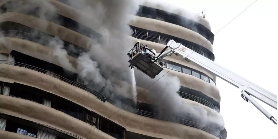 Rauch quilt aus den Fenstern des 12. Stockes des Crystal Towers in Mumbai (IND) während die Feuerwehr versucht die Flammen zu löschen.