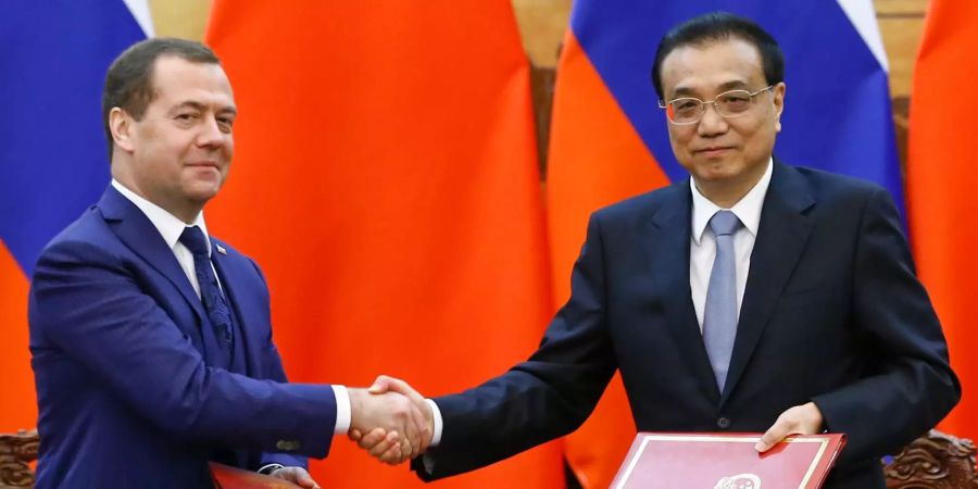 Dmitri Medwedew (l) Ministerpräsident von Russland, und Li Keqiang, Ministerpräsident von China schütteln sich die Hand.