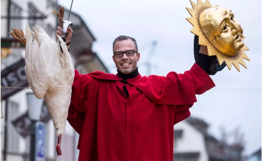 Jan Erni, einer der beiden erfolgreichen Schläger, mit seiner geköpften Gans an der traditionellen Gansabhauet auf dem Rathausplatz in Sursee.