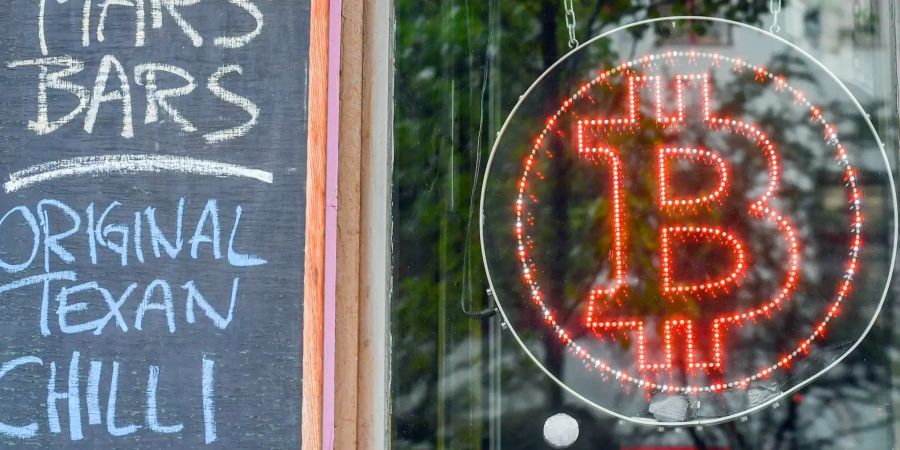 Ein Bitcoin-Logo hängt im Schaufenster.